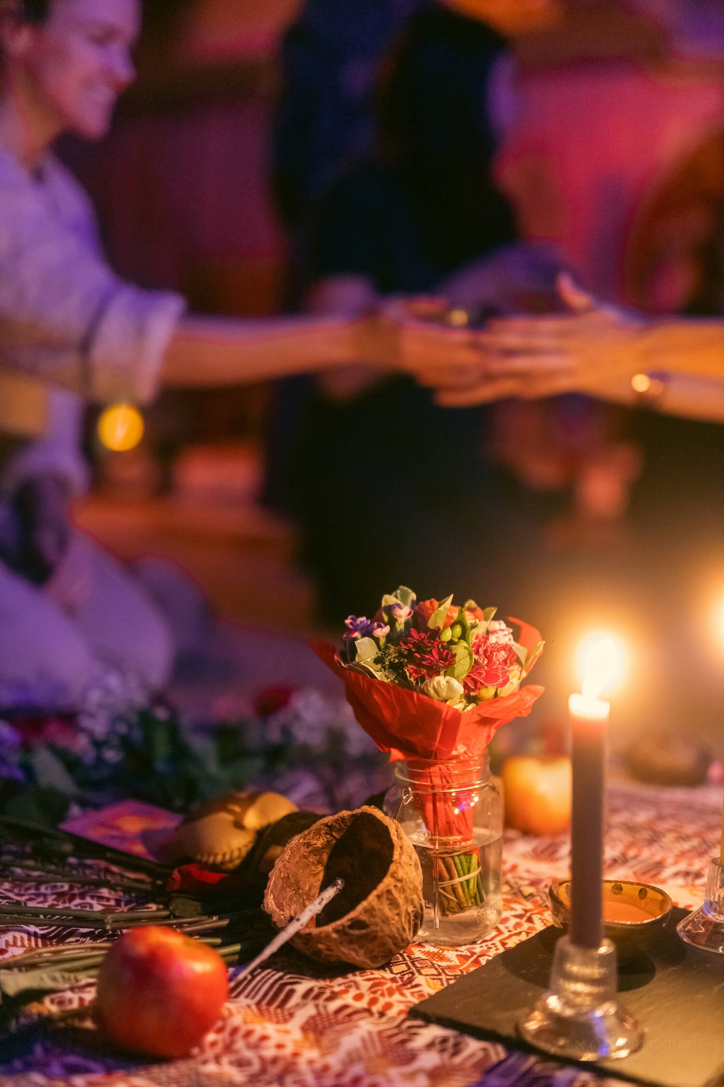 cacao ceremony altar with candles, flowers, and an apple