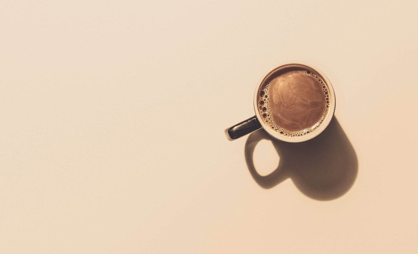 A lone cup of cacao in a beige background