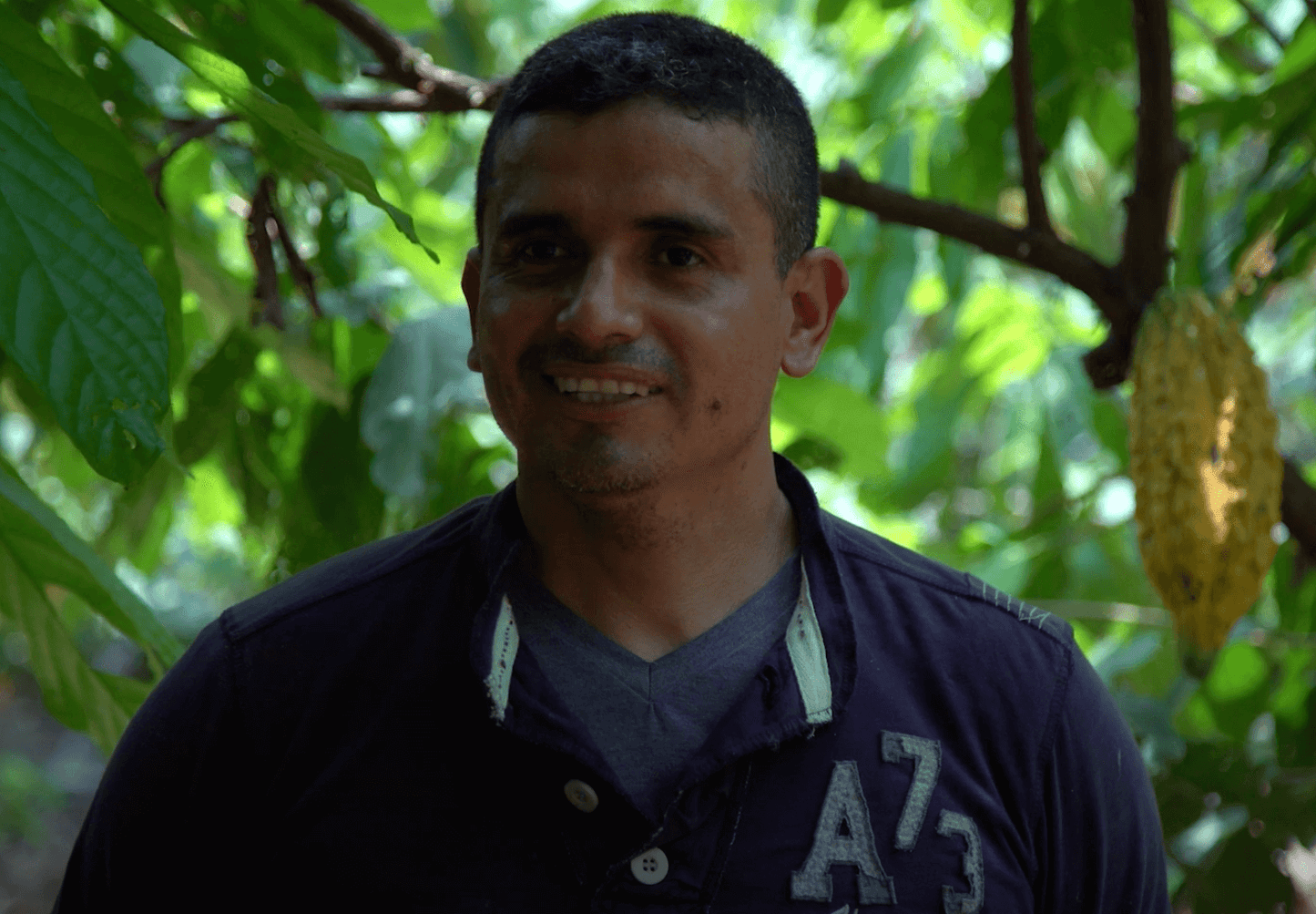 Cacao farmer on his cacao finca with cacao in back