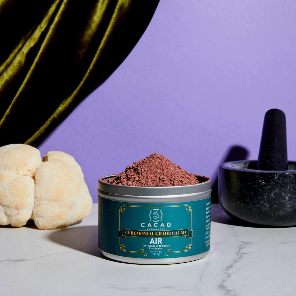 
                  
                    Cacao granule in a teal container with a purple background
                  
                