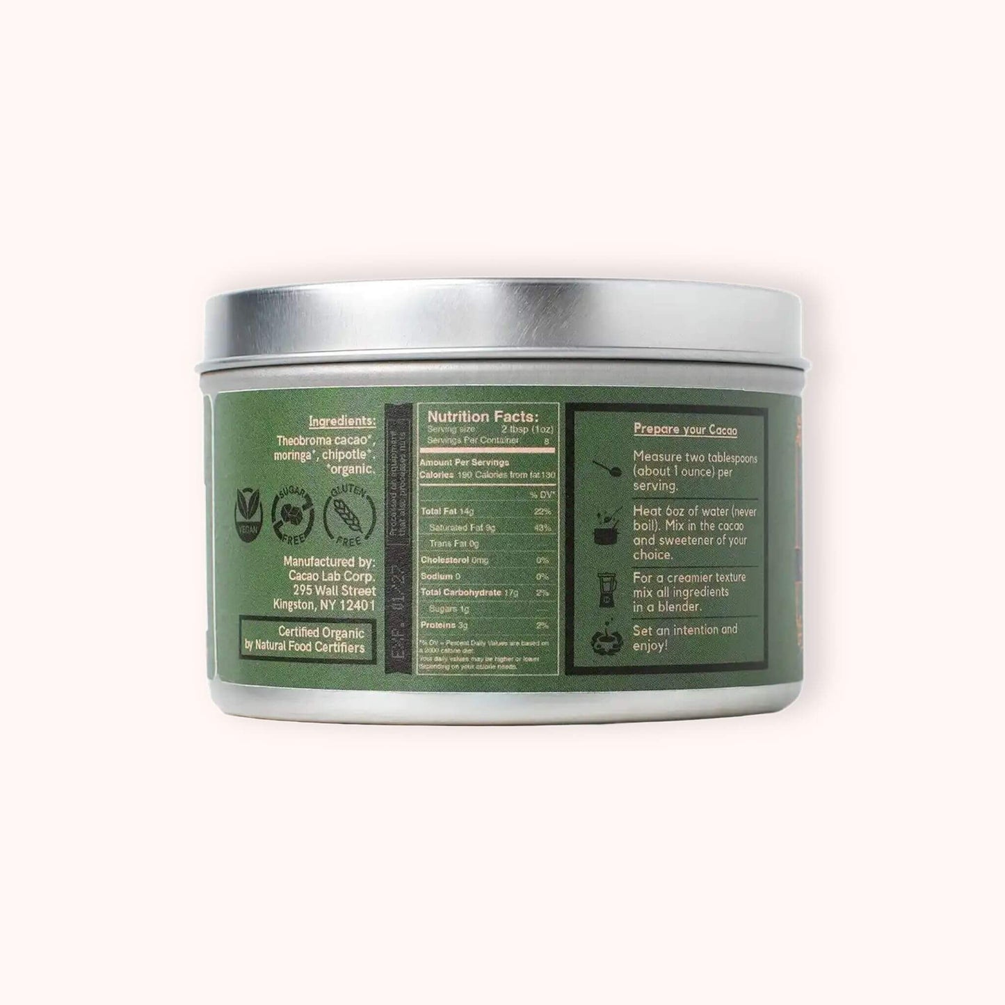 A silver metal tin of Cacao Laboratory ceremonial caco shown from the back, displaying the green and black product label with ingredients, nutrition facts, and instructions.