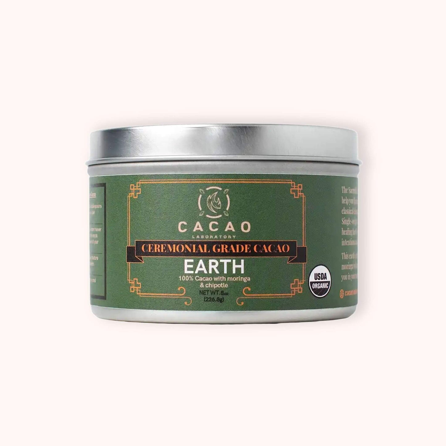 A silver metal tin of Cacao Laboratory Earth Ceremonial Grade Cacao, featuring a dark green label with gold and white text, set against a solid off-white background.