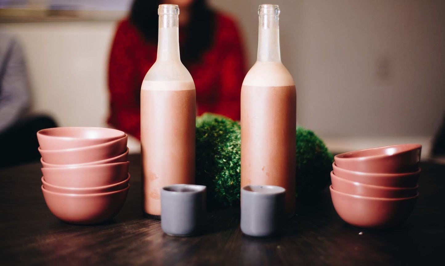 Carafes of ceremonial cacao with clay serving bowls