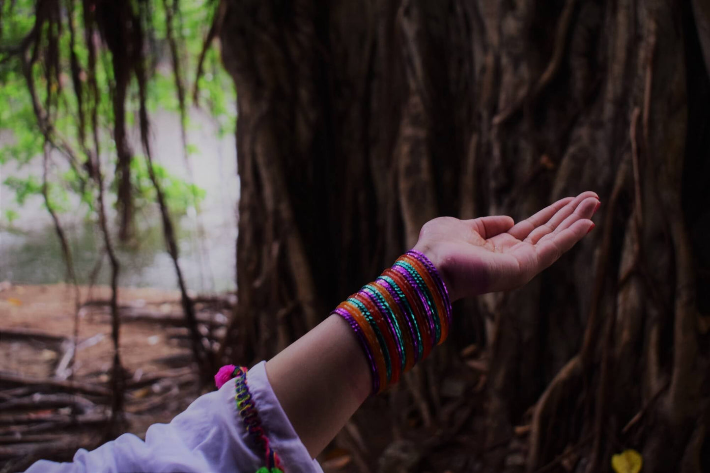 outstretched arm with bracelets in the jungle