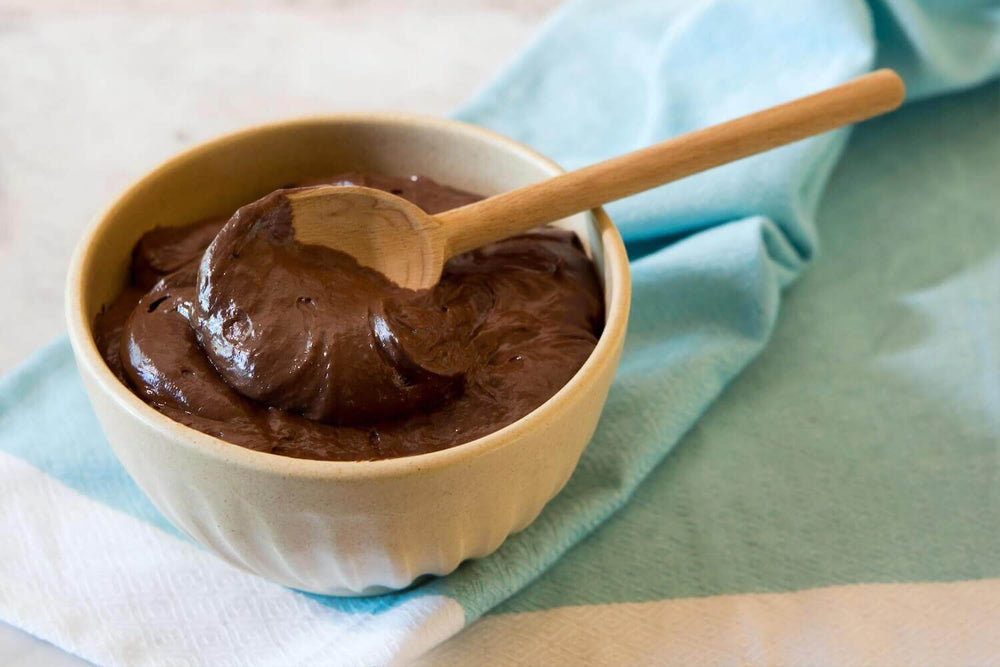 Rich cacao mousse in a bowl with a spoon