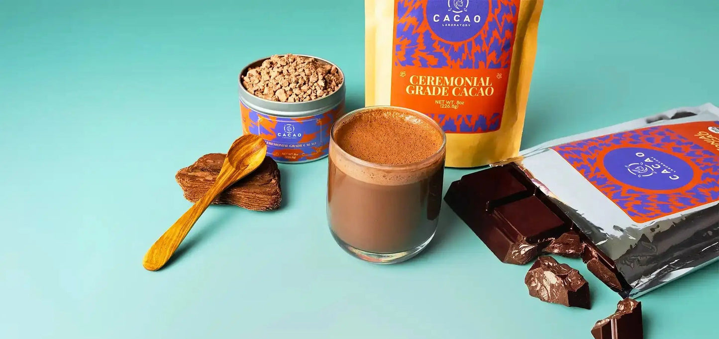 Ceremonial Grade Cacao products including a glass of cacao, chocolate bars, and a container on a teal background.