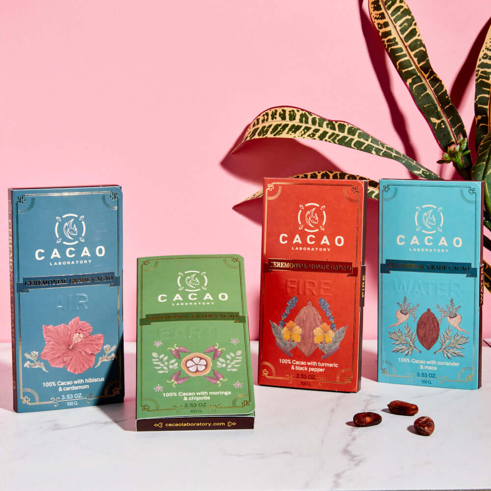 
                  
                    Five Cacao Laboratory chocolate bars in different flavors on a pink background with a plant.
                  
                
