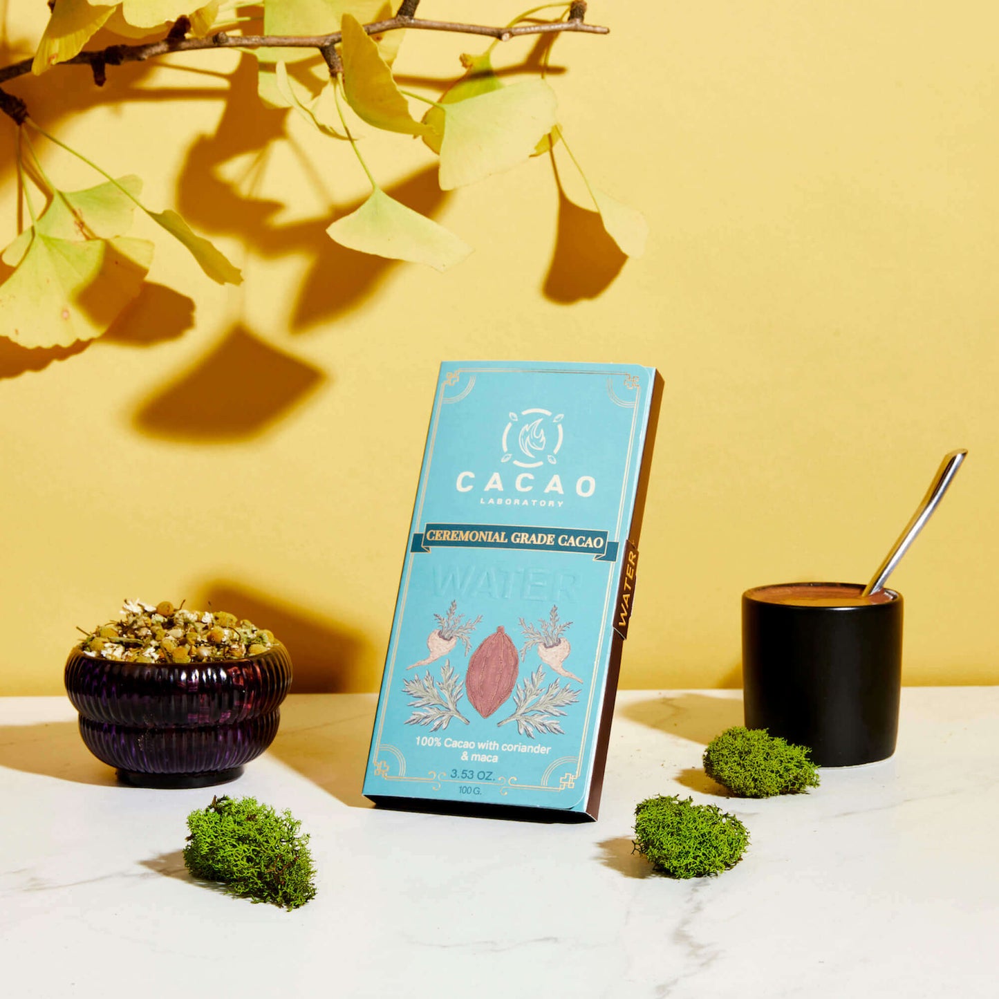 
                  
                    Cacao packaging with a cup and decorative elements on a yellow background
                  
                